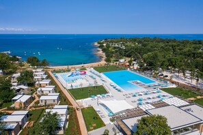 Una piscina al aire libre de temporada, sombrillas
