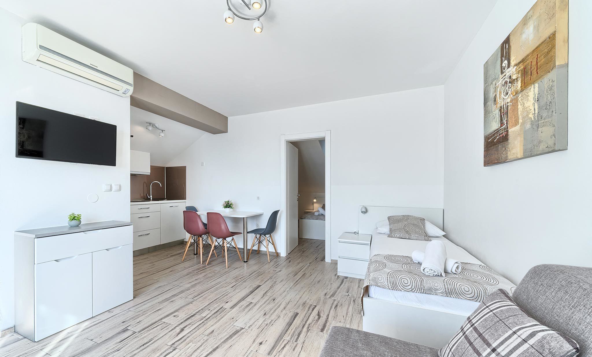 A modern apartment with a kitchen, dining area, and living room.