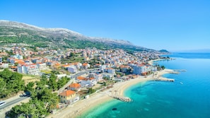 A coastal town with a beach and clear blue waters. - Stipe Residence (Podstrana)