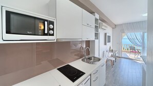 Eine moderne Küche mit integriertem Mikrowellenherd, einer Spüle und einem Induktionskochfeld.