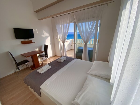 A hotel room with a bed, a TV, a desk, and a chair. - Stipe Residence (Podstrana)