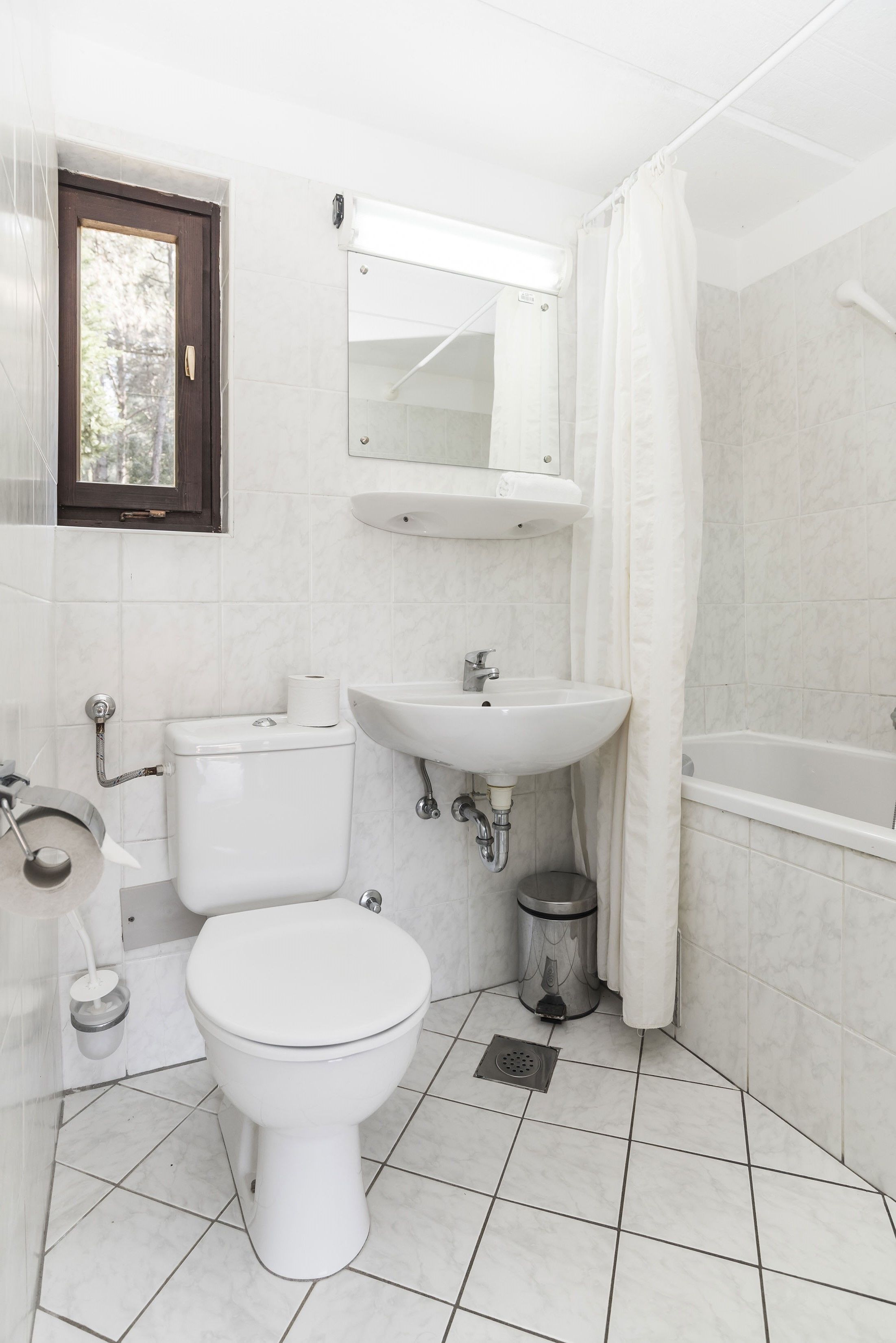 A bathroom with a toilet, sink, and bathtub.