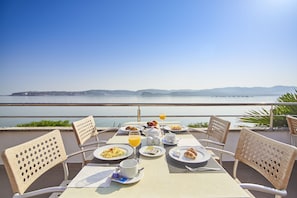 A table set for breakfast with a view of the sea and mountains. - Apartments Kanegra Plava Laguna (Buje)