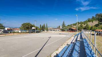 Ein Sportplatz im Freien mit blauen Sitzgelegenheiten und blauem Himmel.