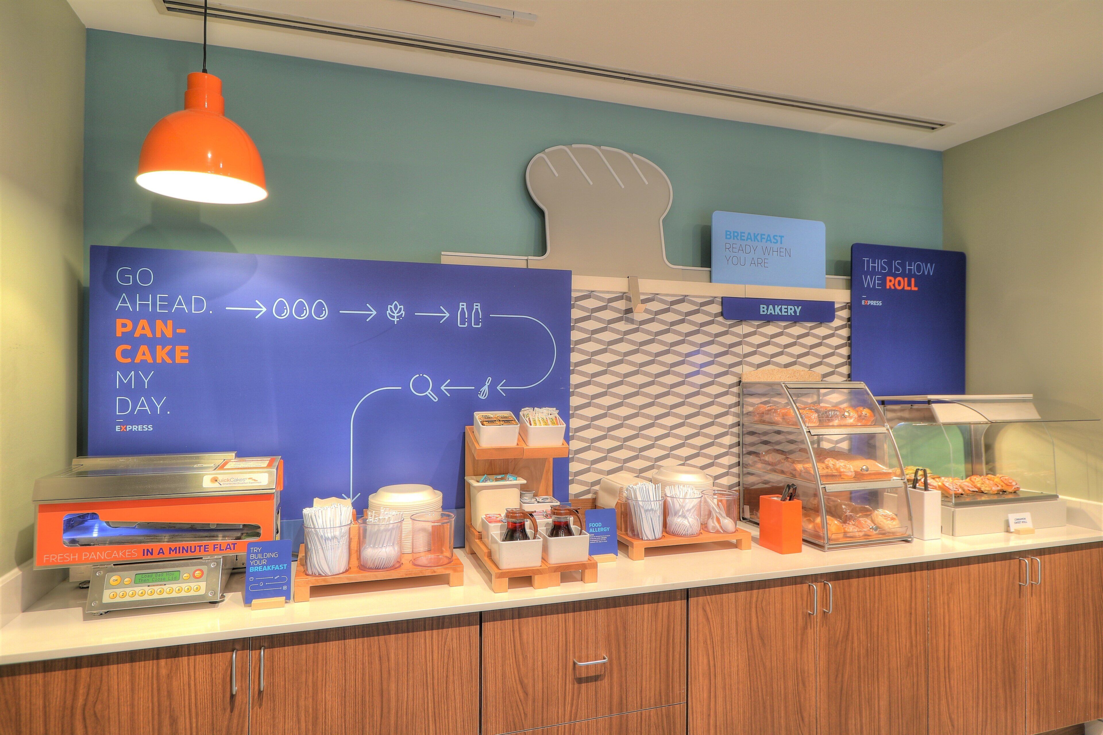 A breakfast buffet area with a sign indicating the direction to the bakery.