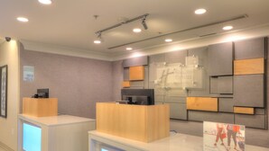 A reception area with a modern design, including a reception desk, a digital display, and a signboard. - Holiday Inn Express Hotel & Suites Mobile/Saraland by IHG (Saraland)