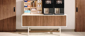 A modern kitchen with a wooden cabinet, a coffee machine, and storage shelves. - Holiday Inn Express Hotel & Suites Mobile/Saraland by IHG (Saraland)