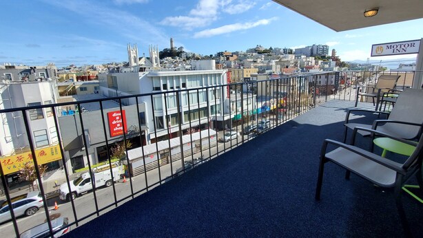 A balcony with a view of a cityscape, including buildings and a church. - Royal Pacific Motor Inn (San Francisco)