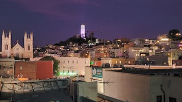 A cityscape at night with a prominent church and a tower on a hill.