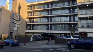 A multi-story hotel with a sign for Motor Inn and Royal Pacific. - Royal Pacific Motor Inn (San Francisco)