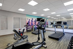 A gym with treadmills, elliptical machines, and free weights.
