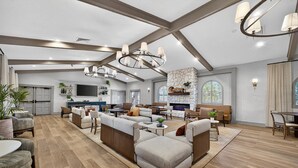 A spacious living room with a fireplace, large windows, and modern furniture. - Mission Resort and Club (Howey-in-the-Hills)