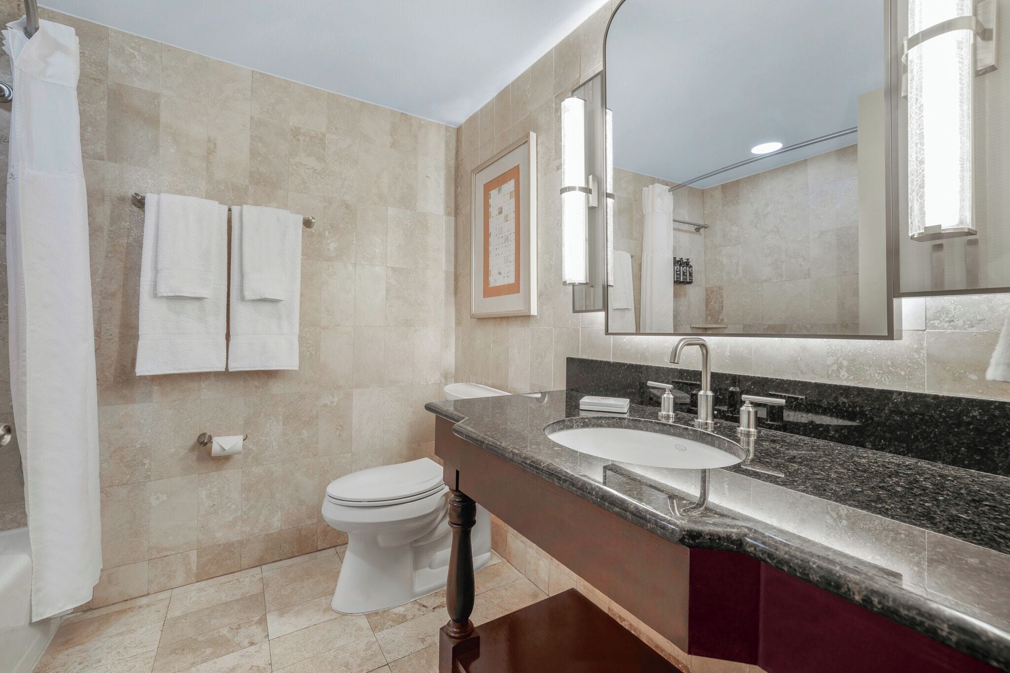 Un baño moderno con un lavamanos grande, inodoro y zona de ducha.