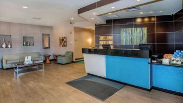 A reception area with a reception desk, a sofa, a coffee table, and a small side table.