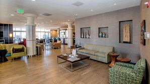 A spacious lobby with a modern design, featuring a central coffee table, sofas, and a variety of seating options. - SpringHill Suites Pueblo Downtown (Pueblo)