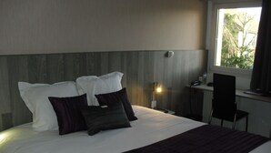 Una habitación de hotel con cama, escritorio y silla.