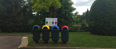 A recycling station with four bins and a signboard.