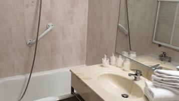 A modern bathroom with a bathtub, a sink, and a mirror.