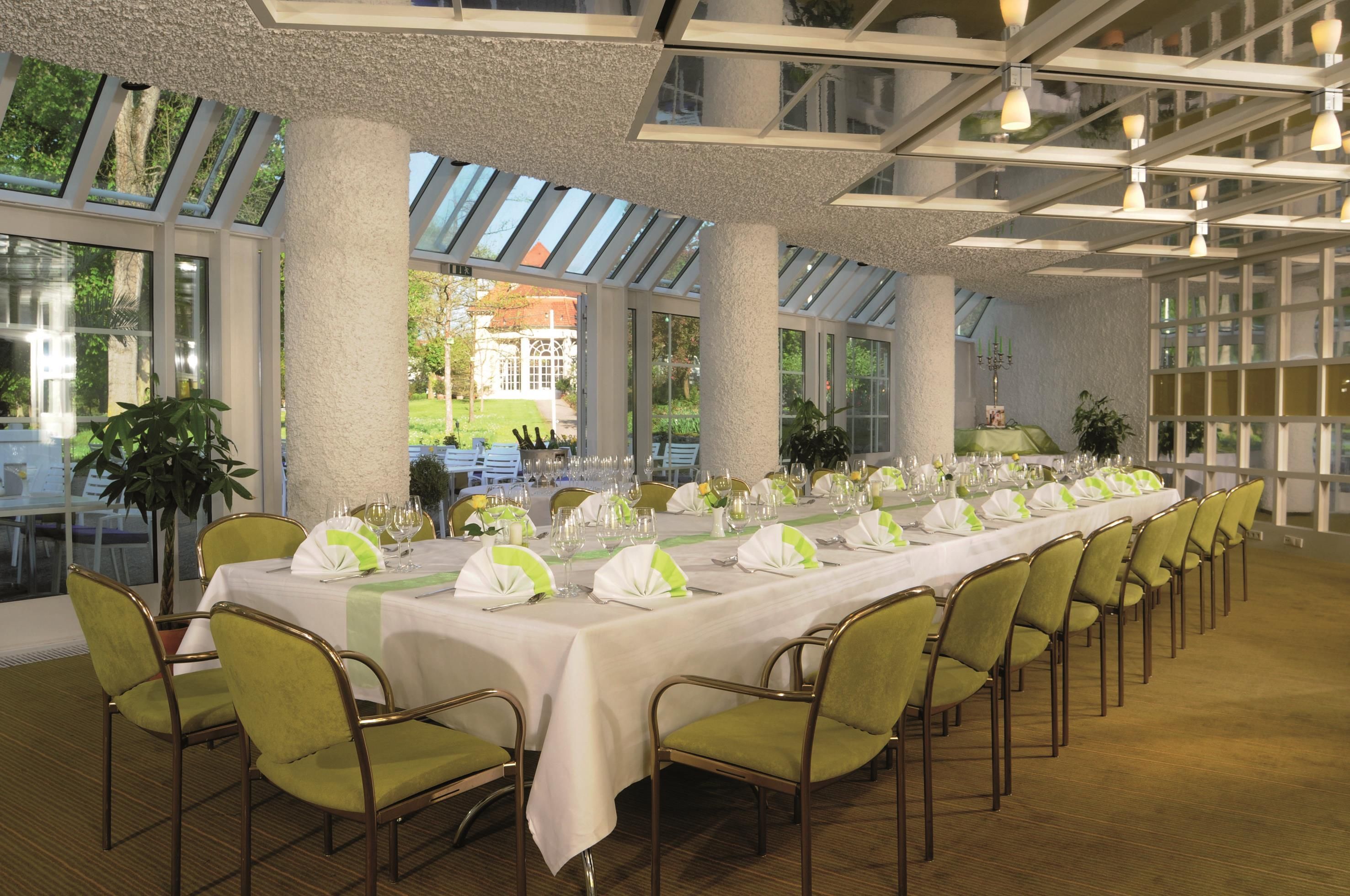 A long dining table set for a formal event with chairs and table settings.