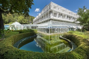A modern building with a glass conservatory and a reflective pond. - Best Western Premier Parkhotel Bad Mergentheim (Bad Mergentheim)