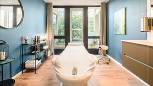 Een moderne badkamer met een grote spiegel, een witte badkuip en een houten vloer.