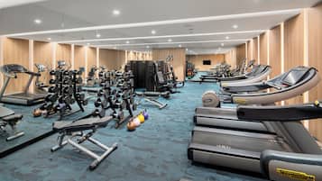 A modern gym with treadmills, weight machines, and free weights.