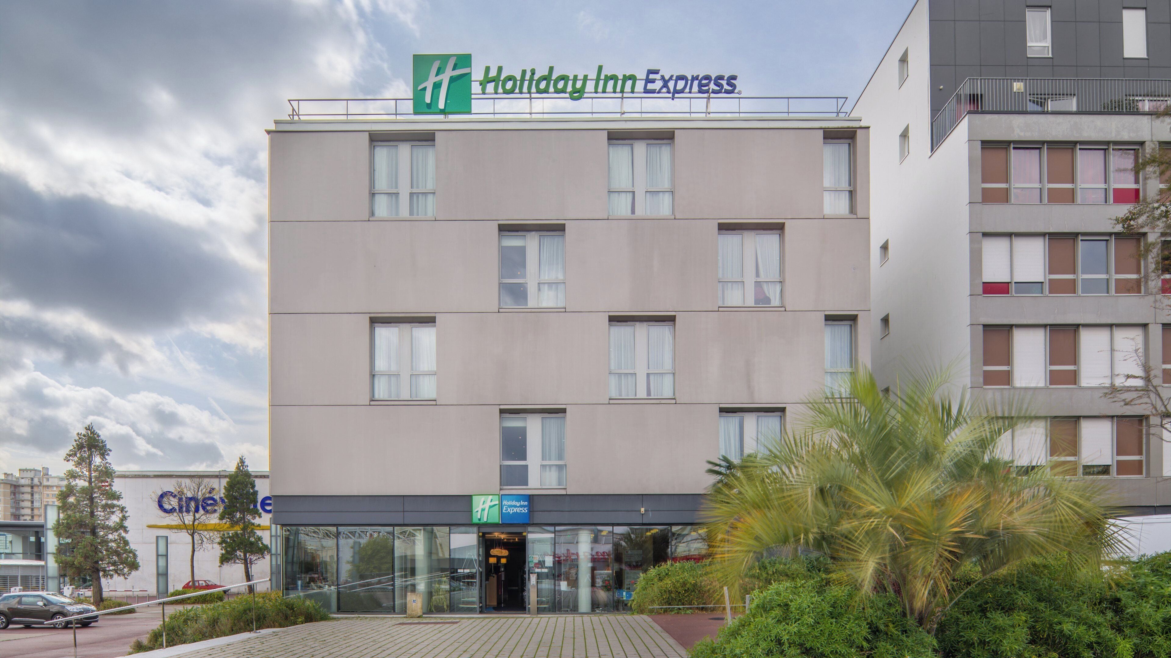 Un hôtel Holiday Inn Express doté d’une façade moderne, de grandes fenêtres et d’une entrée bien visible.