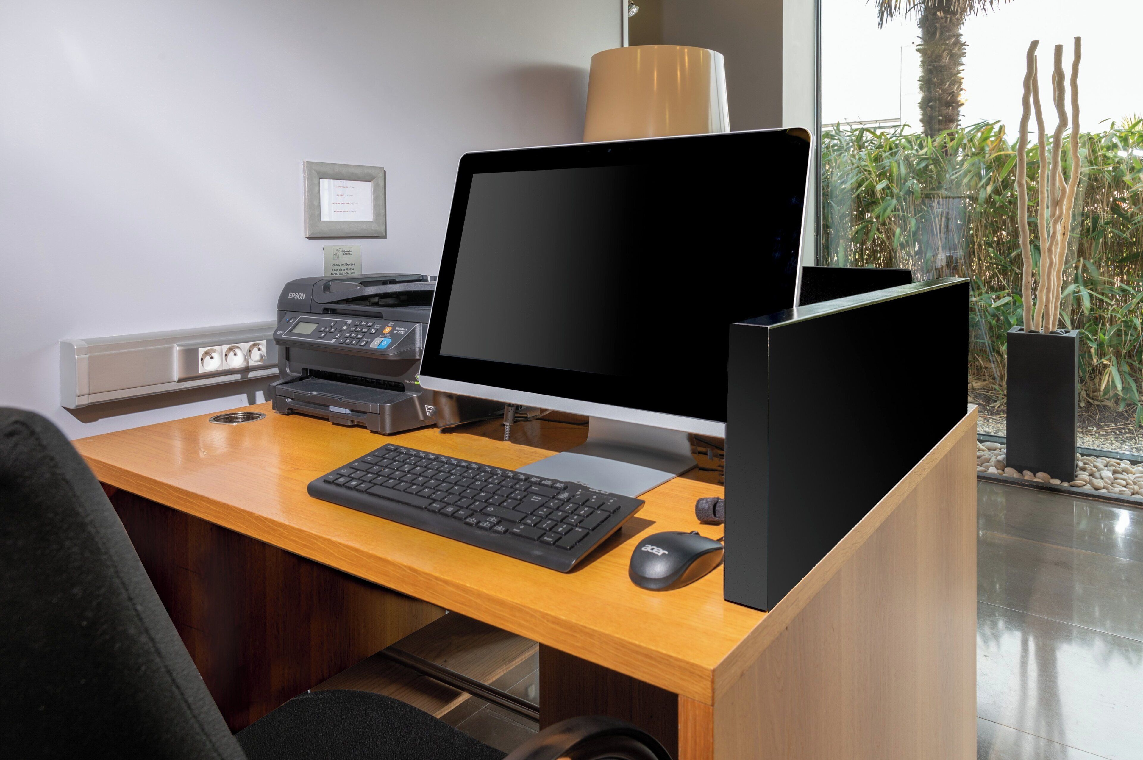 Un escritorio moderno con una computadora de escritorio, teclado, ratón e impresora.