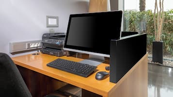 Un escritorio moderno con una computadora de escritorio, teclado, ratón e impresora.