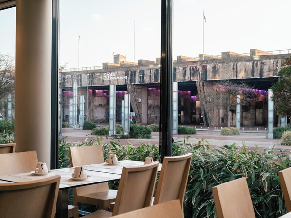 A restaurant with a view of a modern building with the sign "BASE SOUS-MARINE" and a number "10" on it.