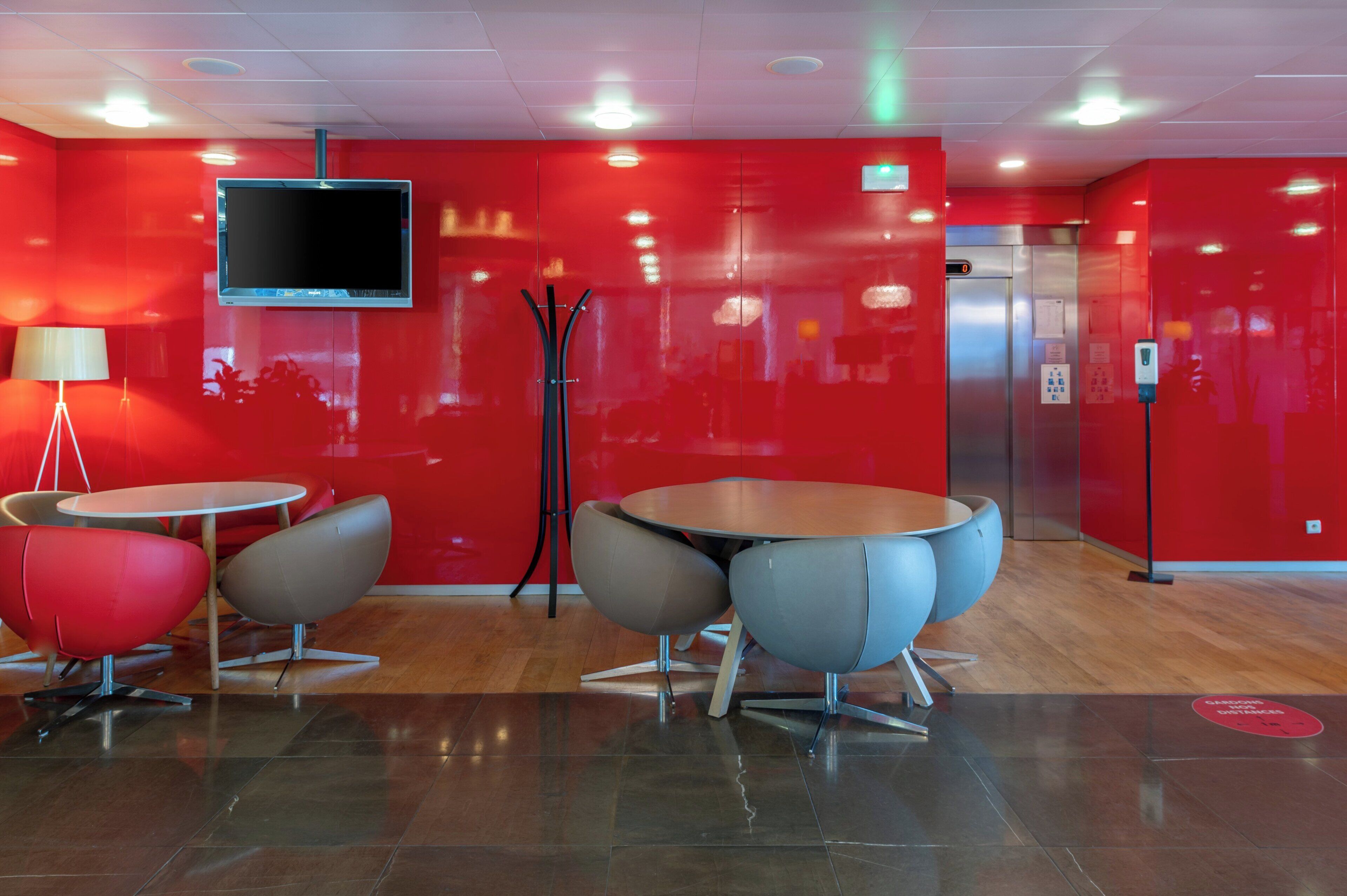 A modern interior with red walls, a flat-screen TV, and contemporary furniture.