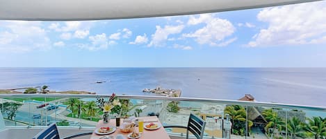 Ein Balkon mit Esstisch, mit Blick auf Strand und Meer.