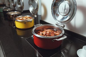 Uma cozinha com uma panela vermelha e uma panela amarela sobre o fogão.