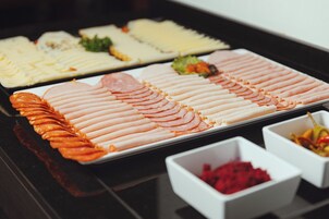 Buffet com diversos alimentos dispostos em bandejas.