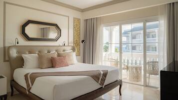 A hotel room with a large bed, a mirror, a window with a view of buildings, and a balcony.