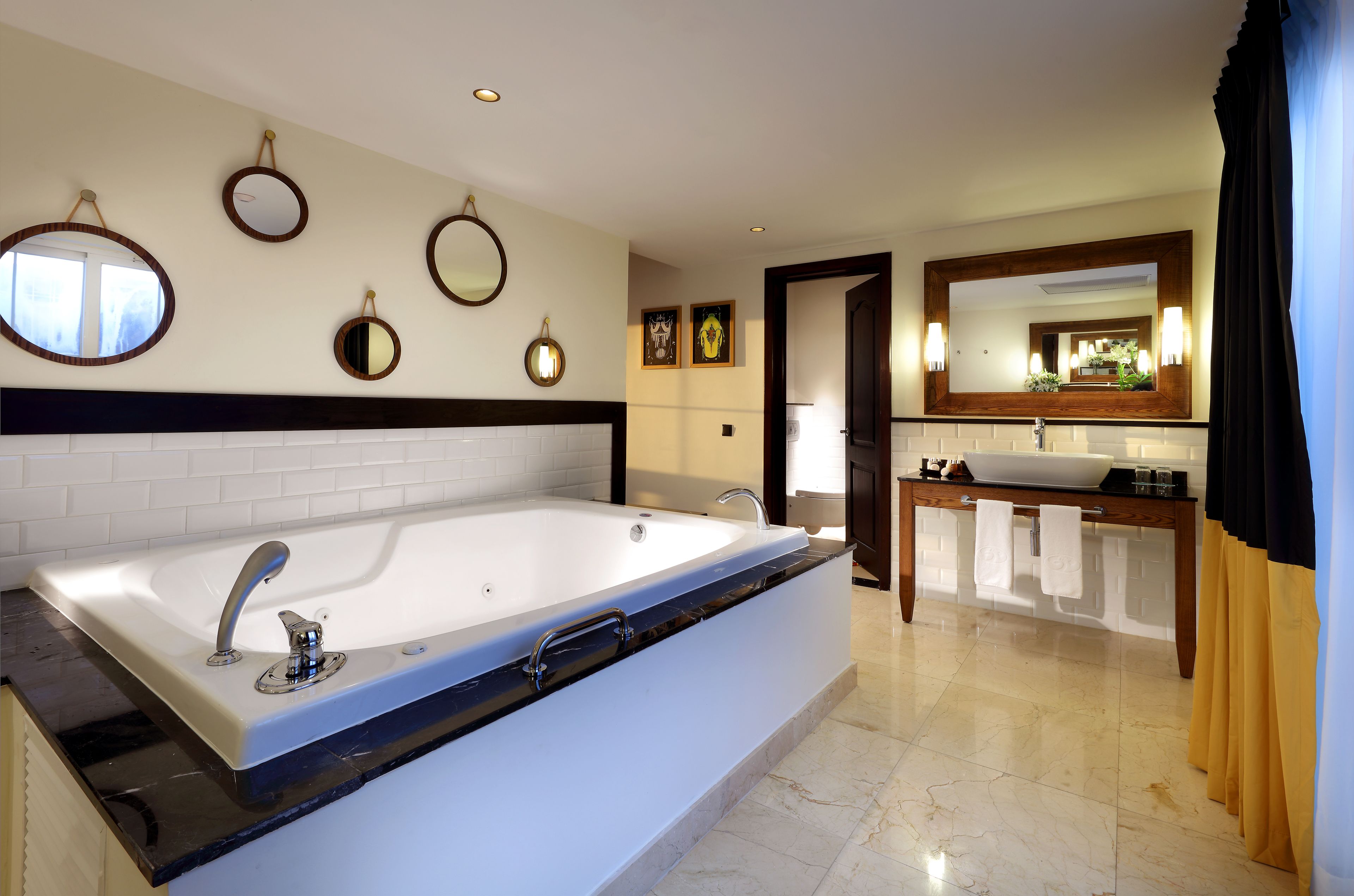 A modern bathroom with a large bathtub, multiple wall mirrors, and a vanity with a sink.