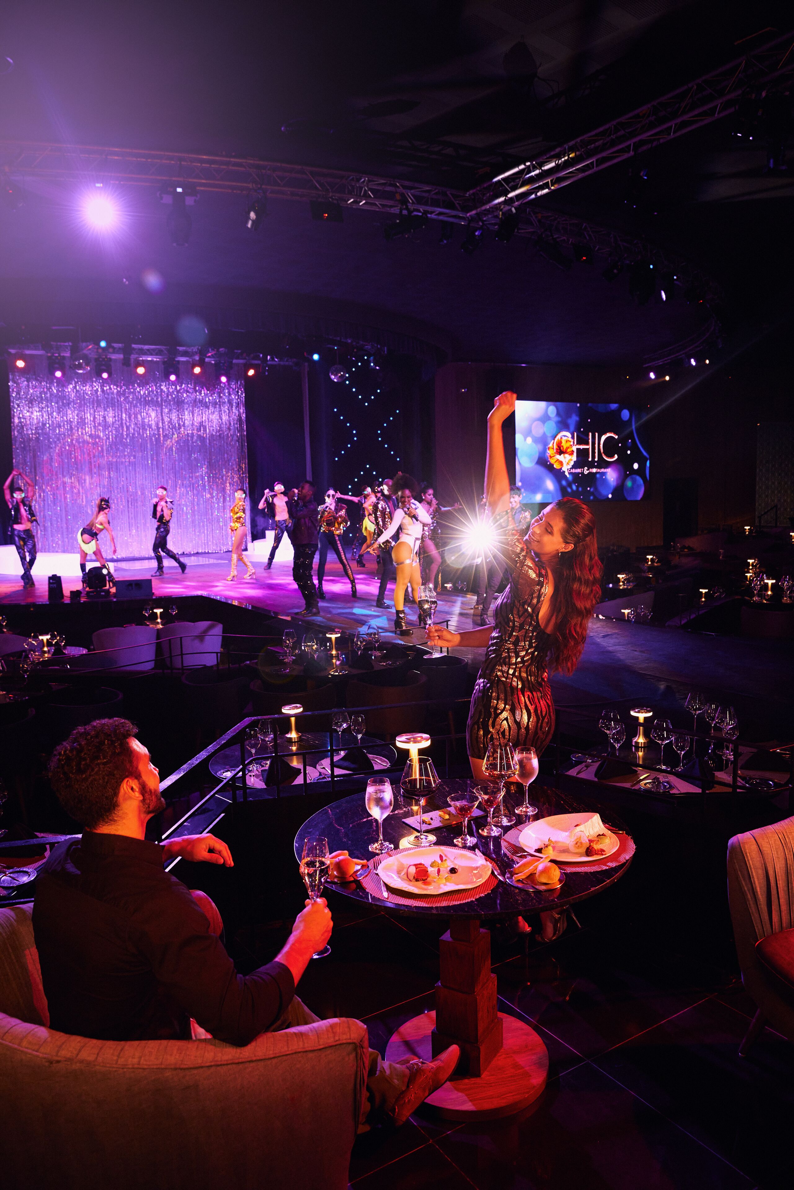 A stage with performers and a large screen displaying "HIC".