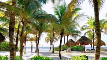 Playa privada, playa de arena blanca, camastros y sombrillas