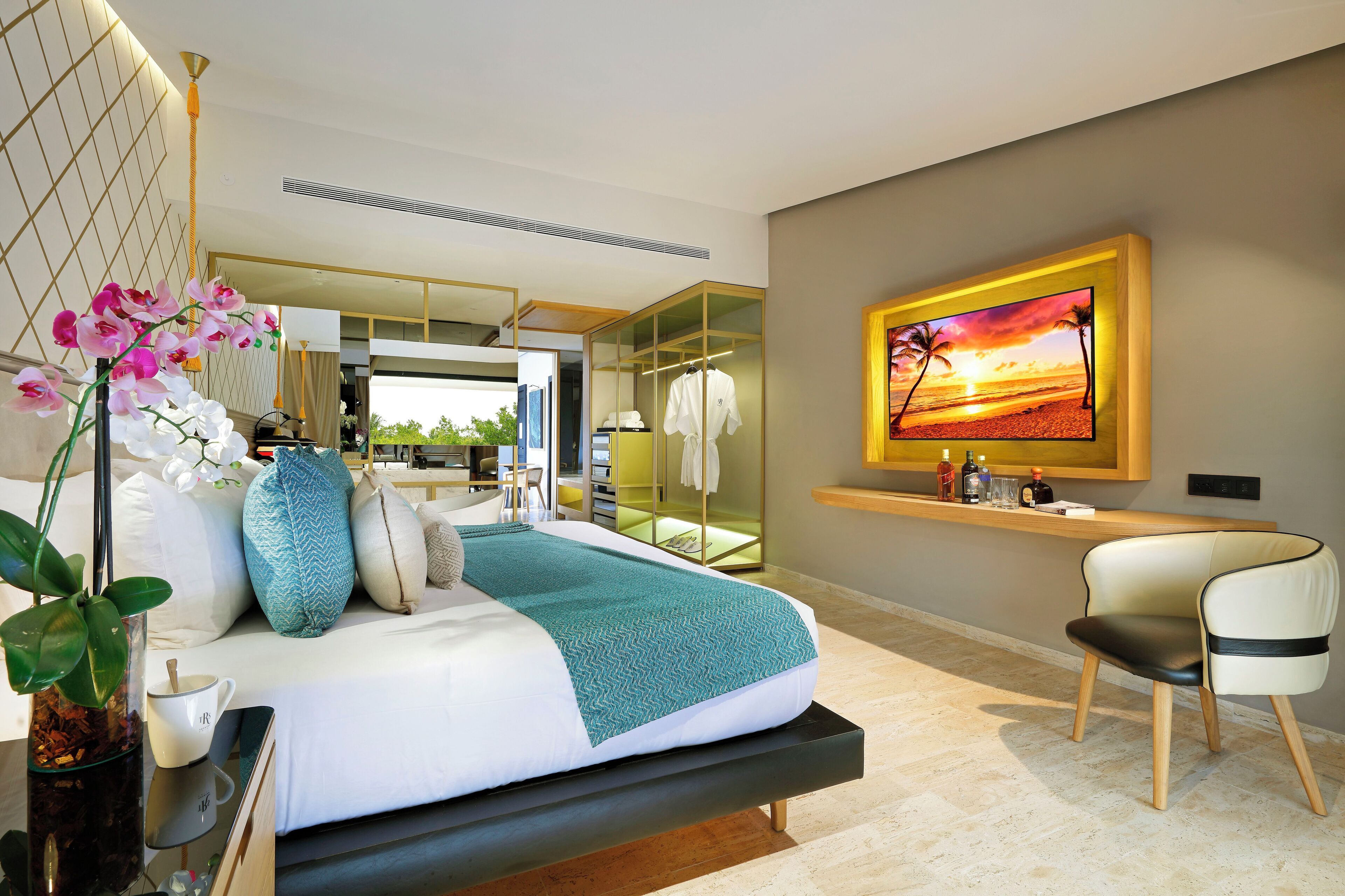 A modern bedroom with a bed, a desk, and a large window.