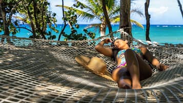 Na praia, areia branca, espreguiçadeiras, guarda-sóis
