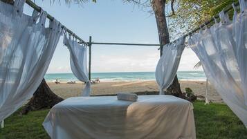 Relax in comfort under a canopy, with beach views and a serene ocean backdrop.
