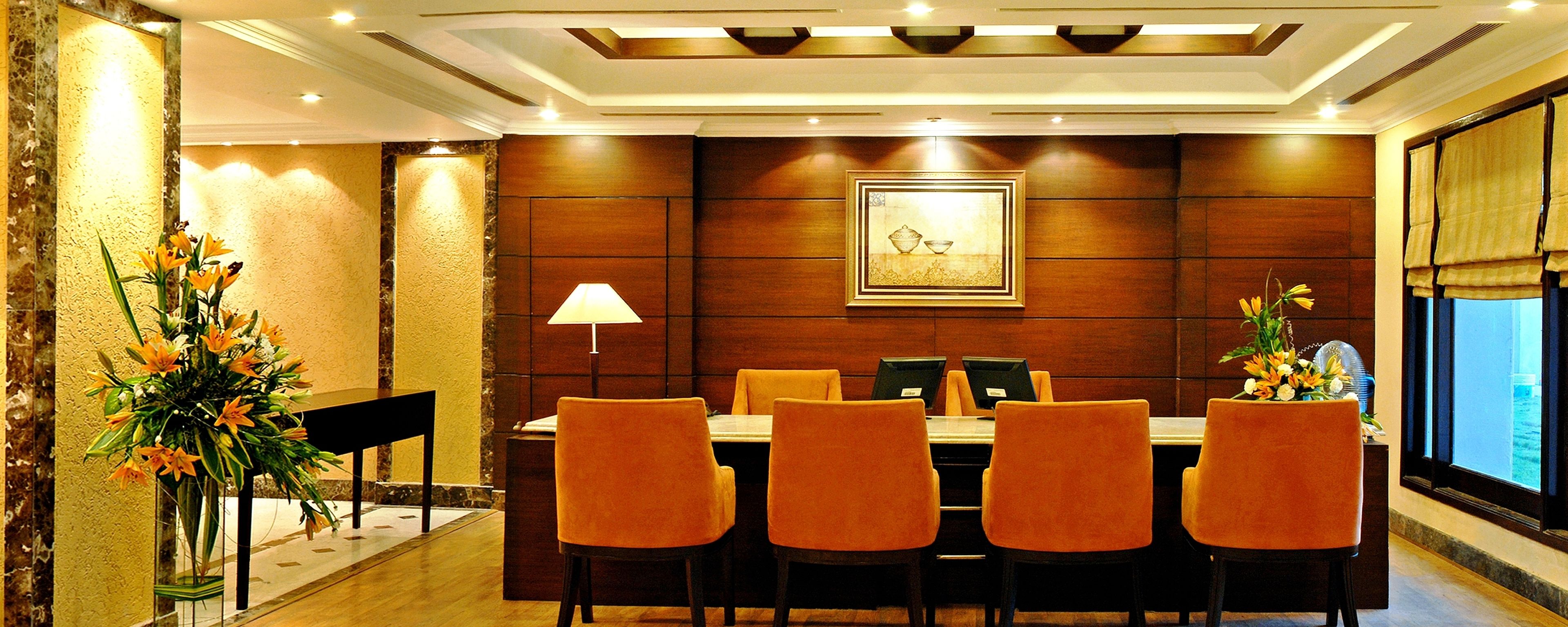 A conference room with a wooden panel wall, a framed picture, and a table with four chairs.