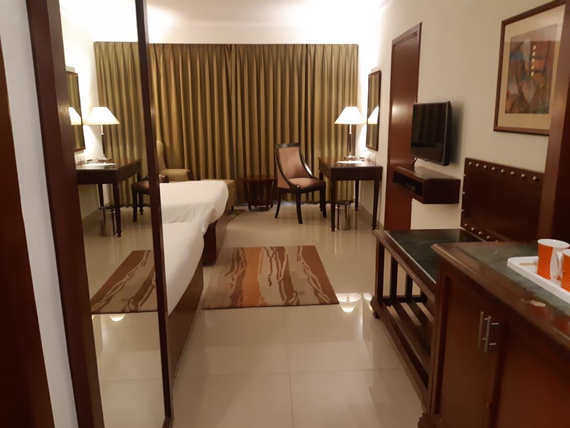 Camera d'albergo con un letto, una scrivania, una sedia, un televisore e un bagno.
