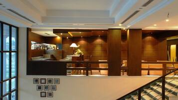 Eine moderne Lobby mit Empfangsschalter, Sitzgelegenheiten und einer Treppe.