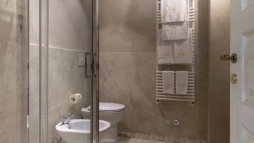 Ein modernes Badezimmer mit einer gläsernen Duschkabine, einem weißen Waschbecken und einer Toilette.