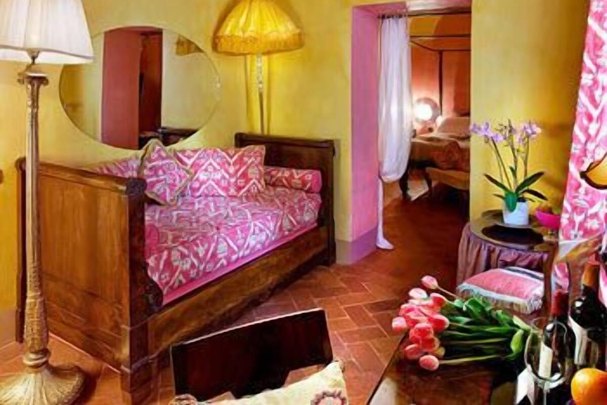 Een knus slaapkamer met een houten bed, een nachtkastje, een lamp en een raam met gordijnen.