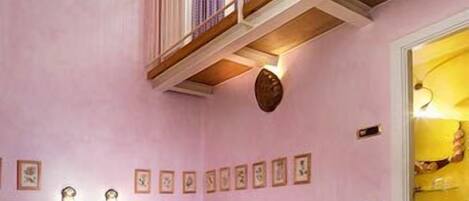 A bedroom with a wooden bed, a small balcony, and a door leading to a bathroom.