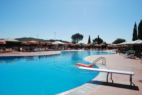 Una piscina al aire libre de temporada, sombrillas