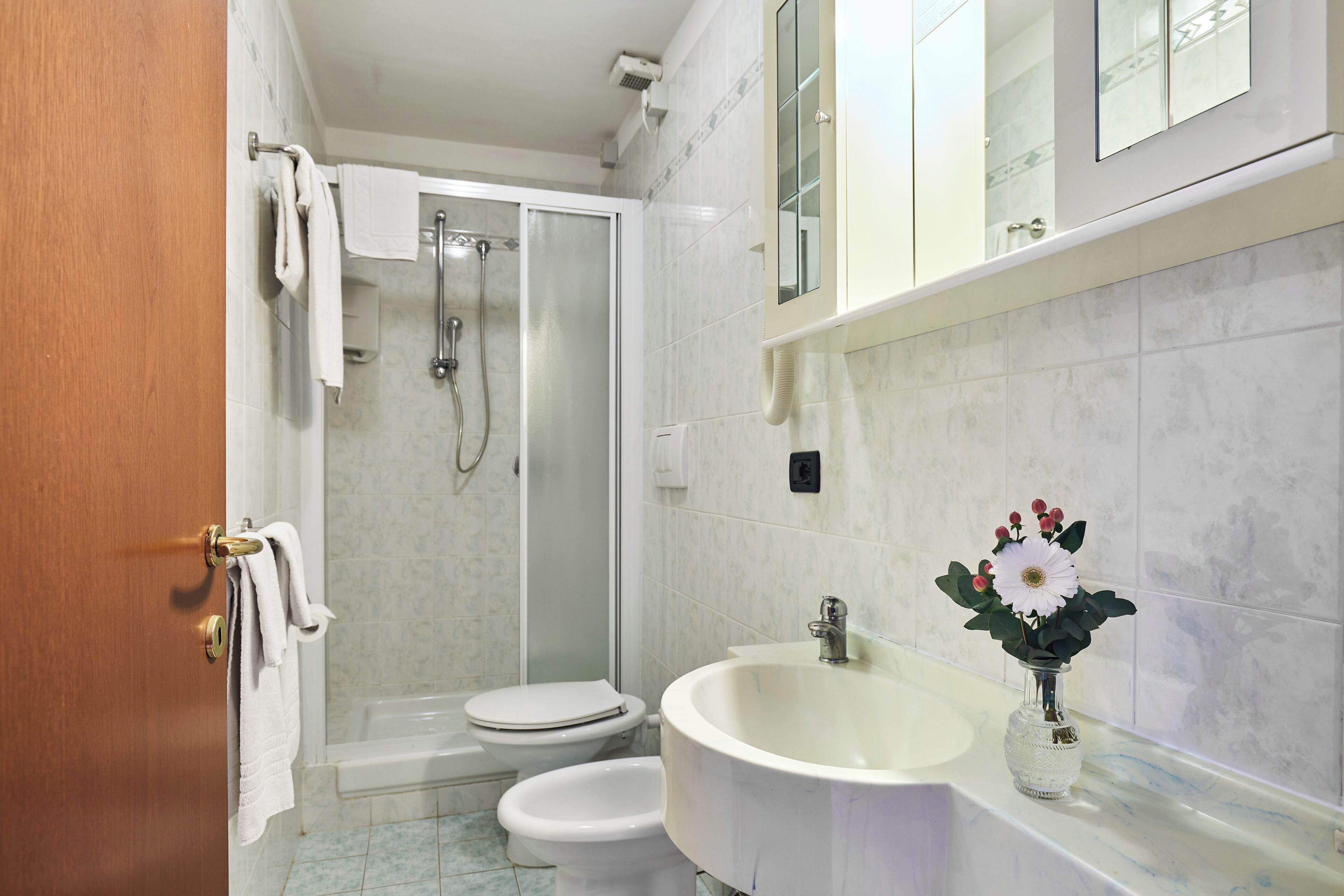 A bathroom with a shower, toilet, and sink.