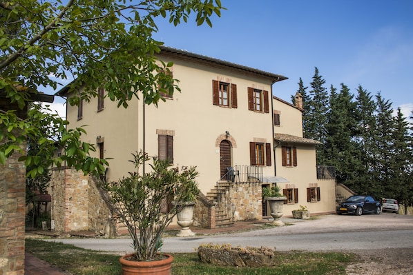 A two-story building with a stone staircase, a balcony, and a car parked in front. - Agriturismo Palazzo Bandino (Chianciano Terme)